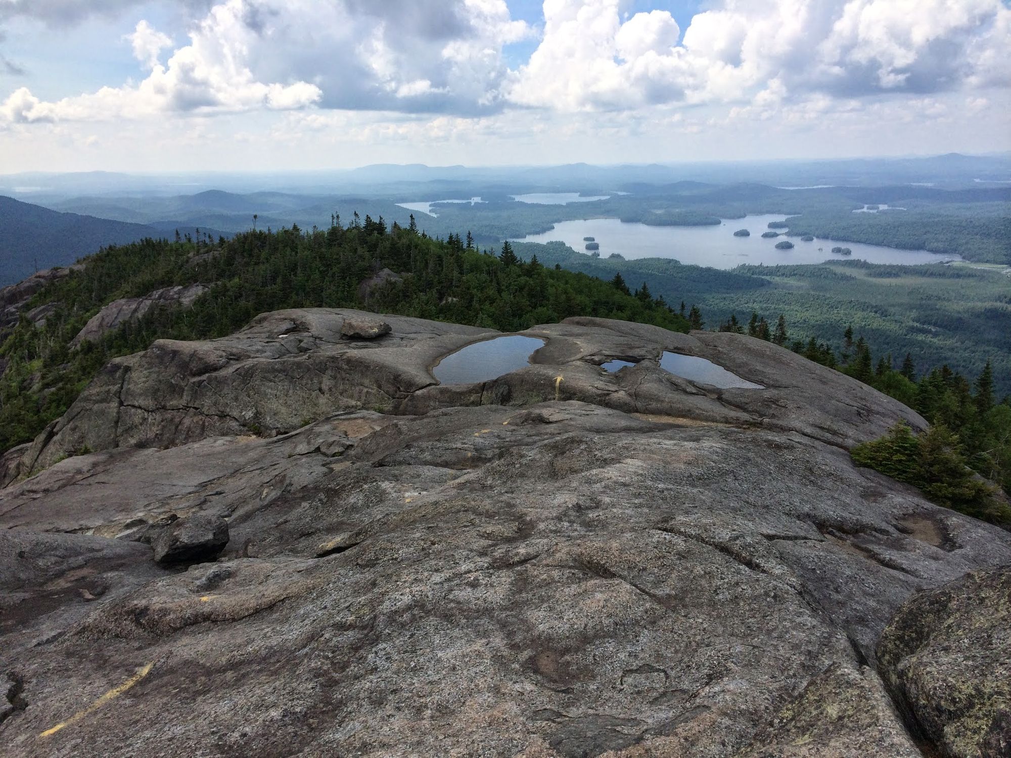A stunning view from the Ampersand mountain trail hike of the forests and lakes below