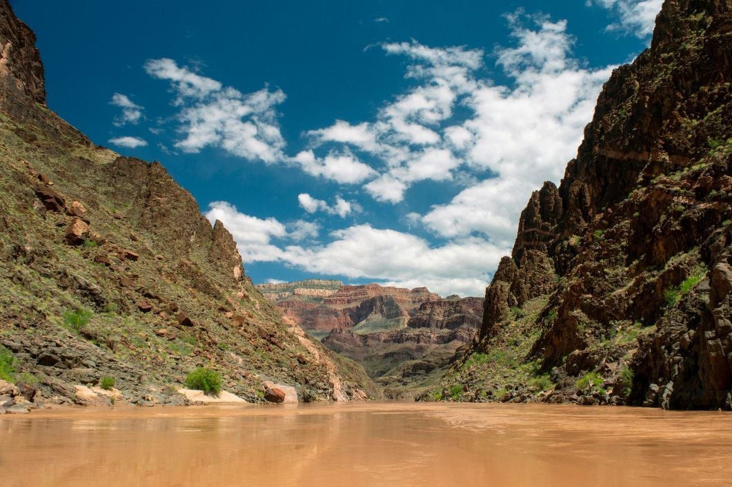 A sediment-filled river, with sandstone mountains on either side.