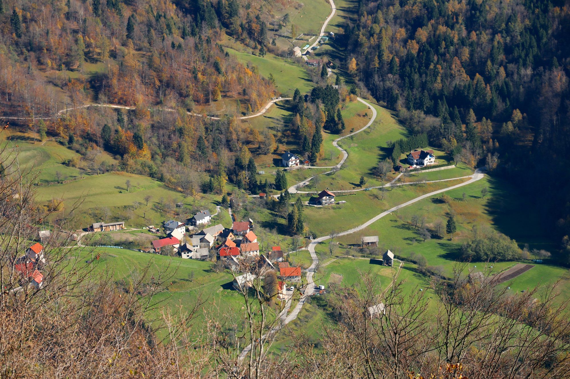 An aerial shot of the Cerkno Hills, with a road wining up through the town and up the mountain.