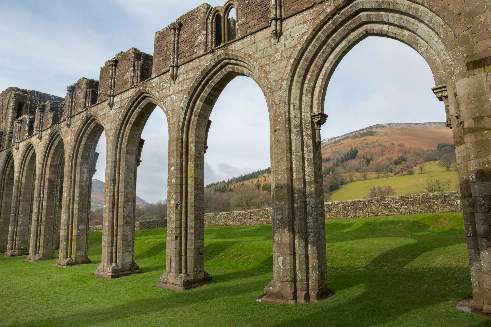 The rolling hills with Offa's Dyke on top, pictured through Llanthony priory's arches