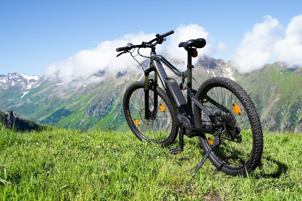 An ebike in the foreground, with cloud-smudged mountains in the background.