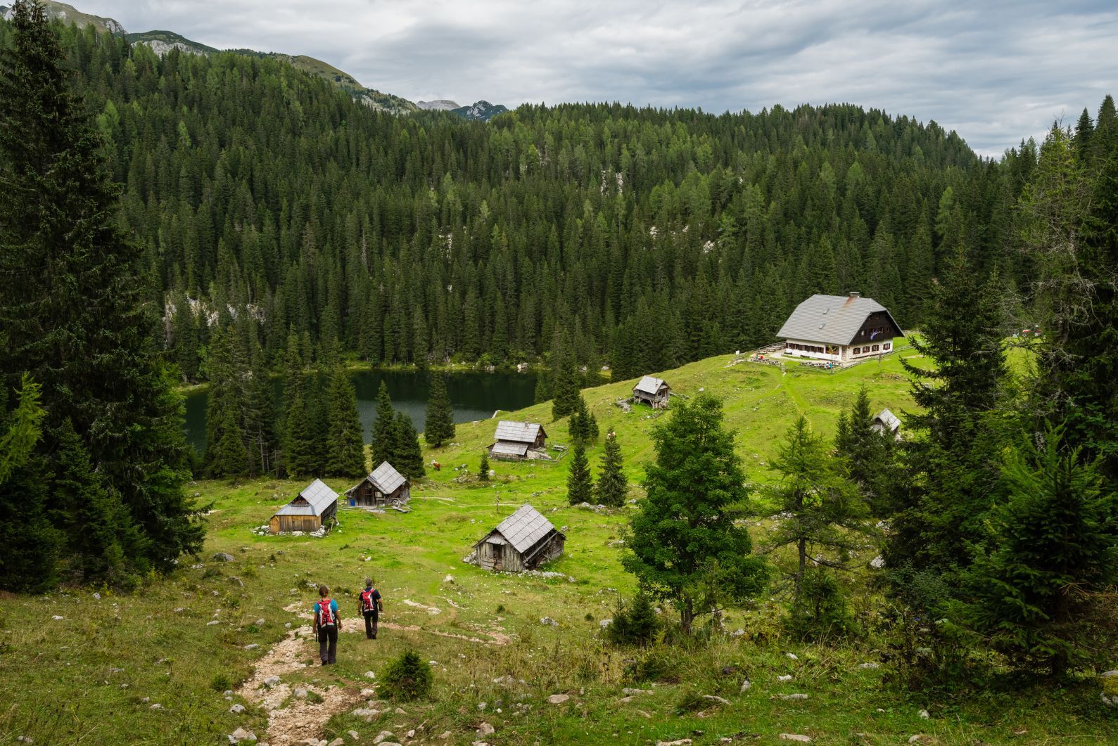 Log cabins and a mountain lake in the mountains of the Slovenian Alps, on the peak Planina Blato