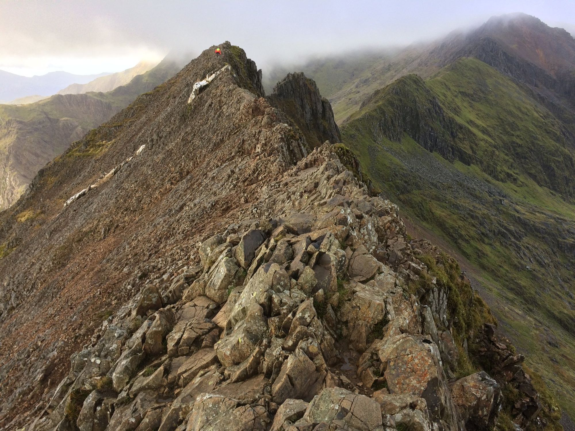 A lone hiker scrambling across Crib Goch.