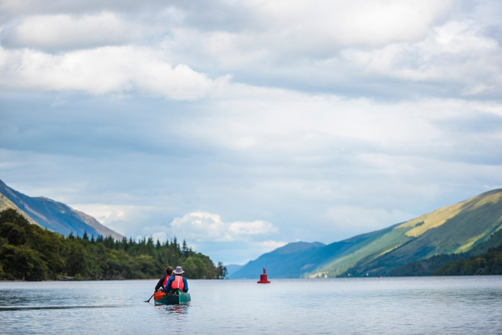 Two people in a canoe on the scenic Caledonian Canal.