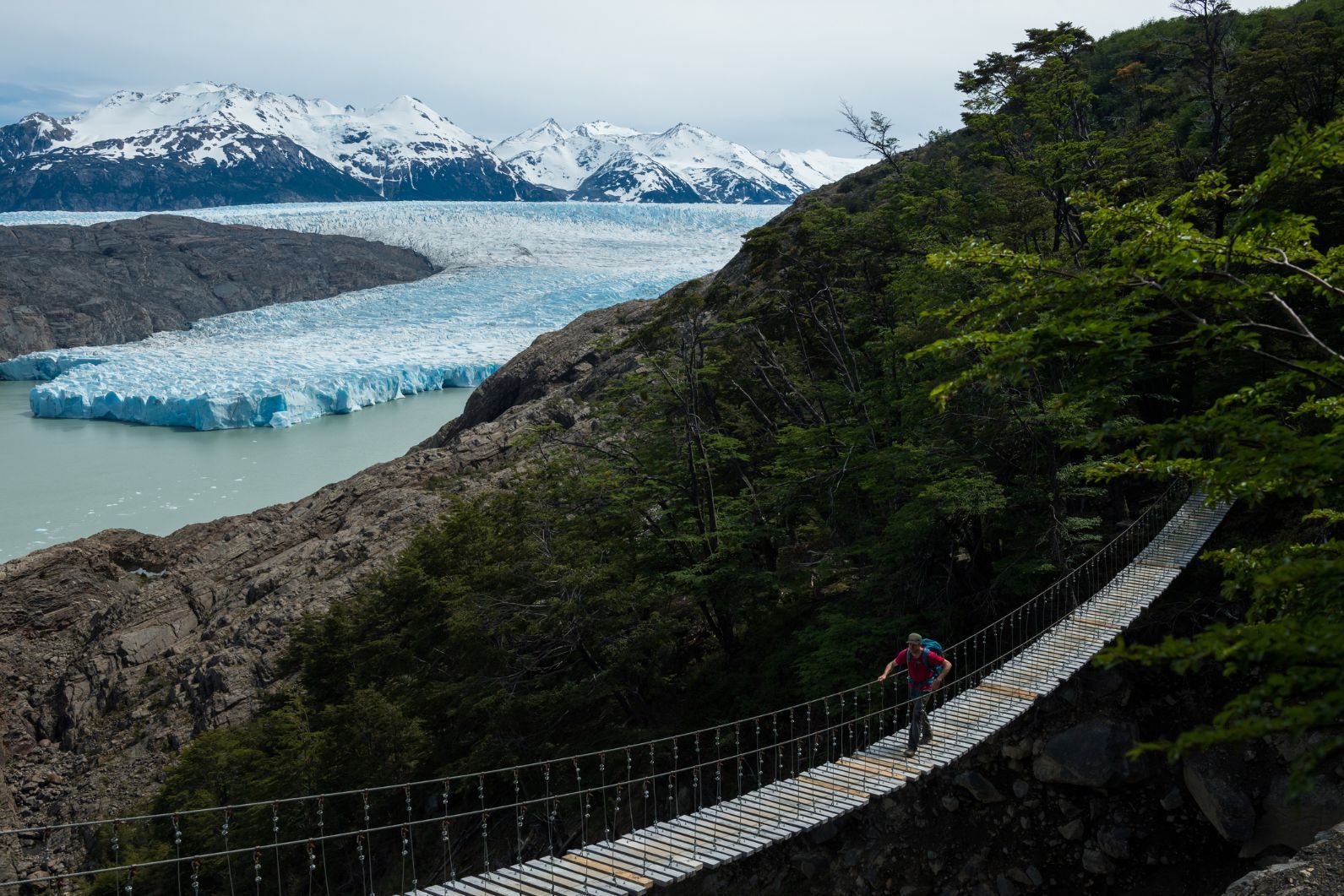 A hiker crossing a suspension bridge in Torres del Paine, Patagonia.