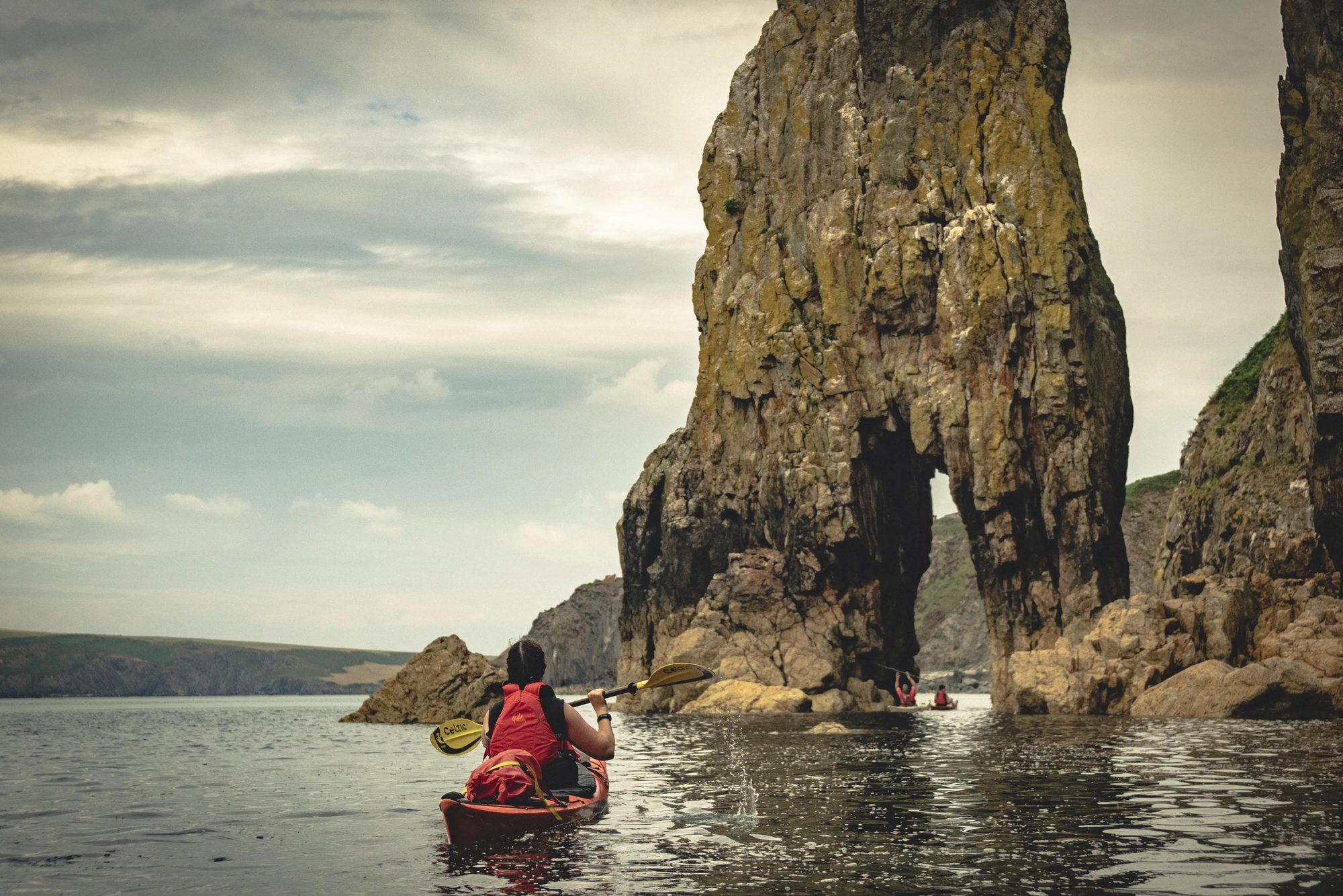A kayaking group travelling along the Pembrokeshire coastline.