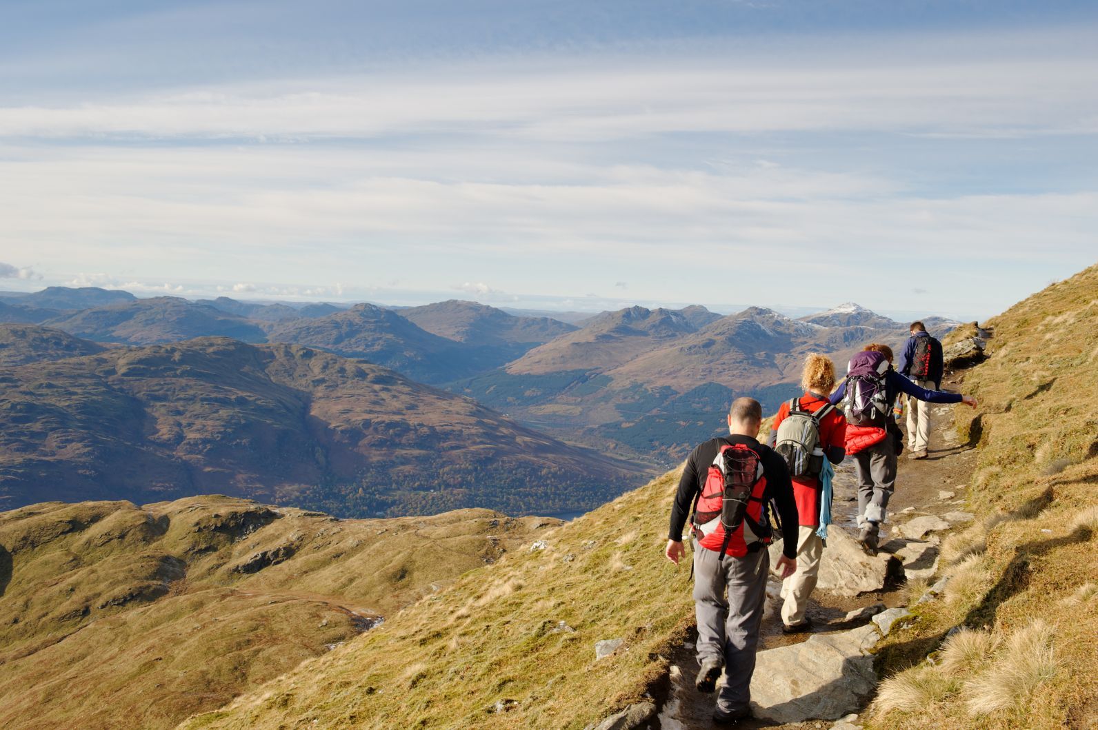 A group of hikers in Scotland climb a mountain.