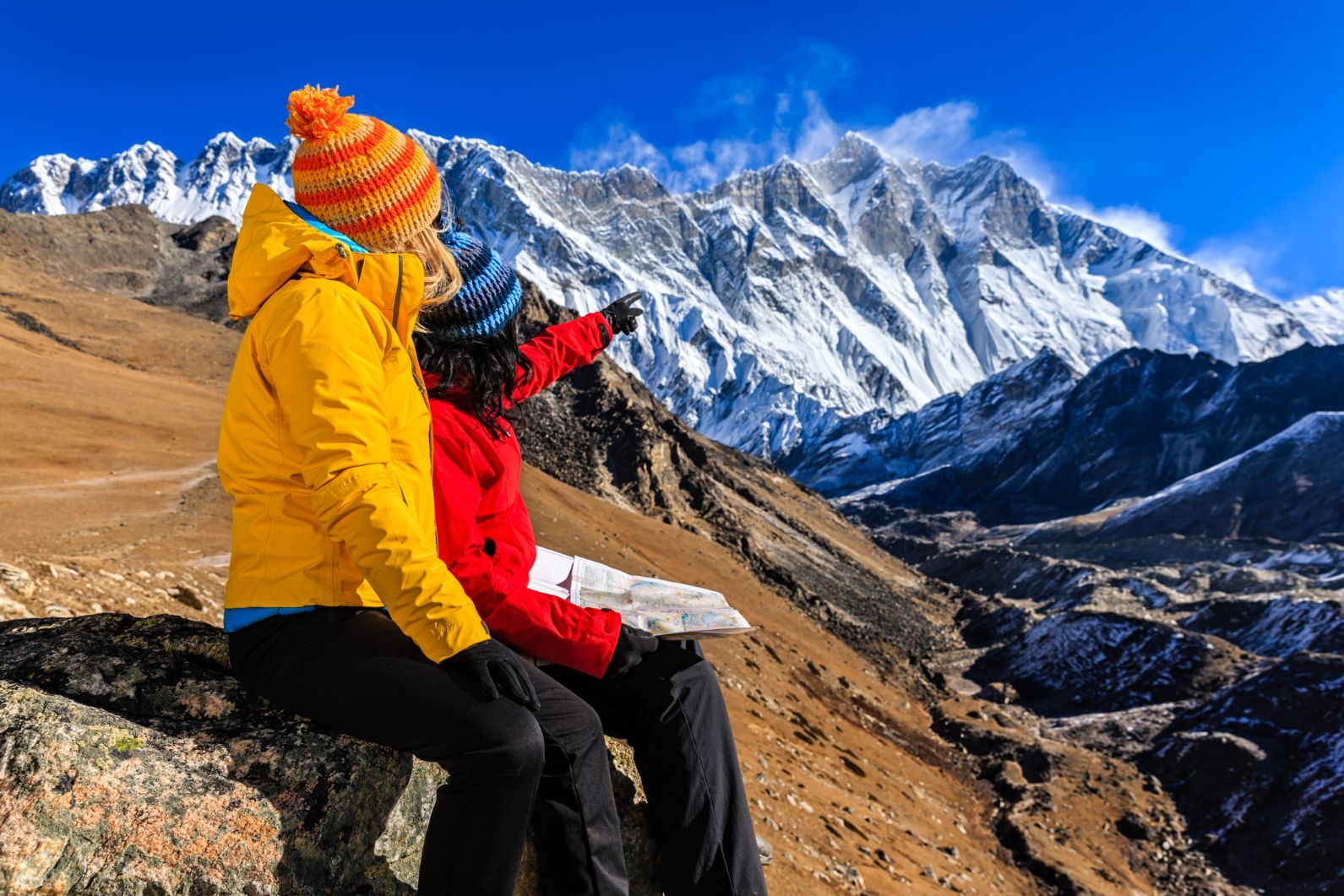 Two hikers look out on the landscape of the Everest Region in Nepal