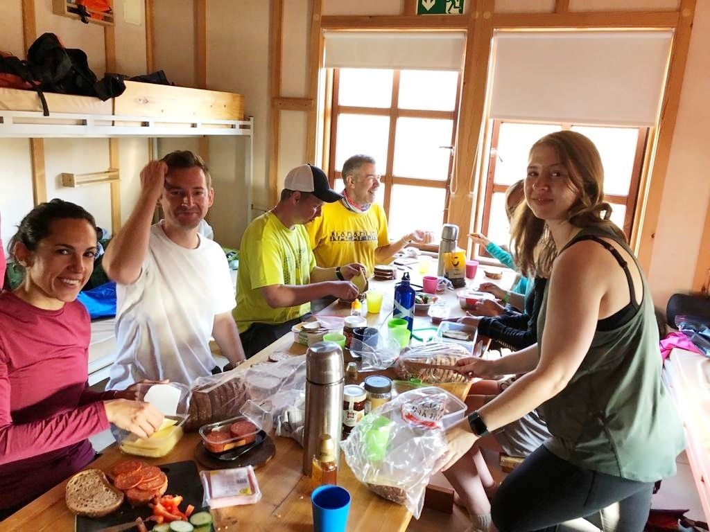A group eating dinner in a mountain refuge in Iceland, on a Much Better Adventures trip.