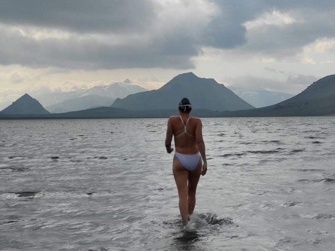 A wild swimmer prepares to enter Swan Lake, in Iceland.