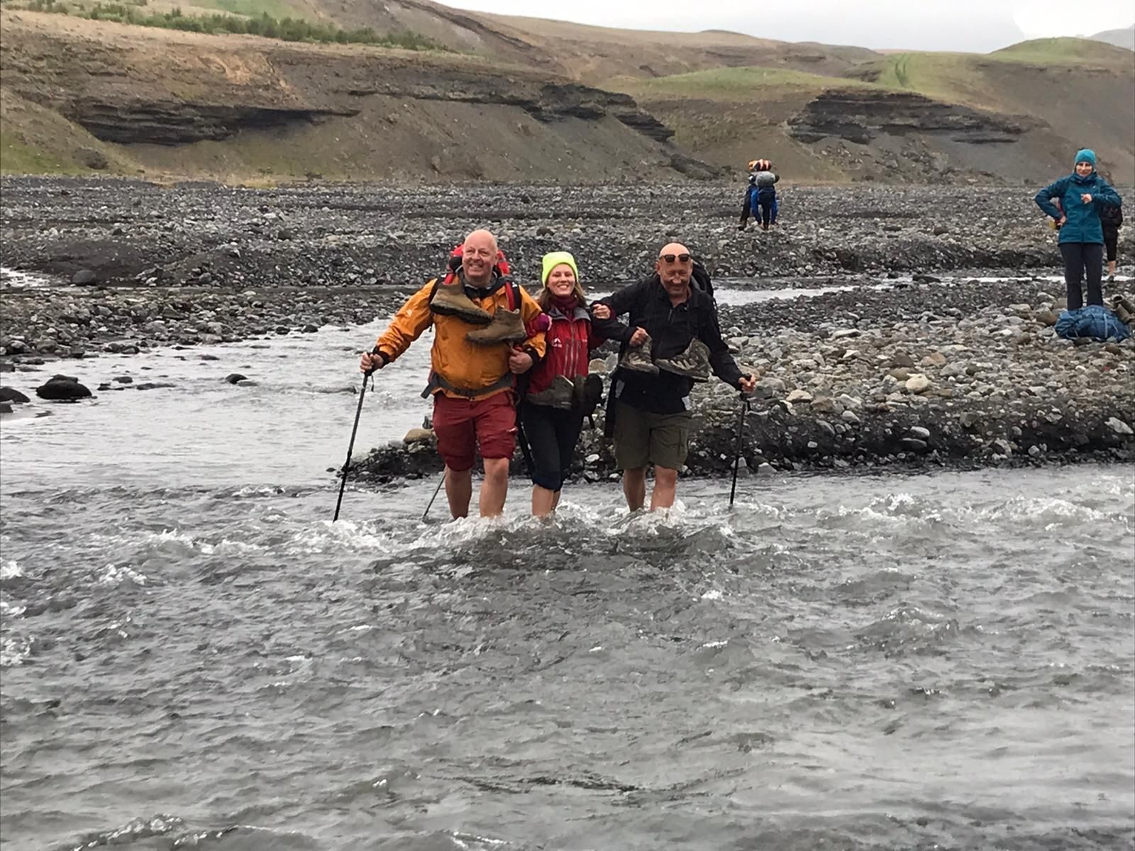 A hiking group crossing the Markárfljót river in Iceland.