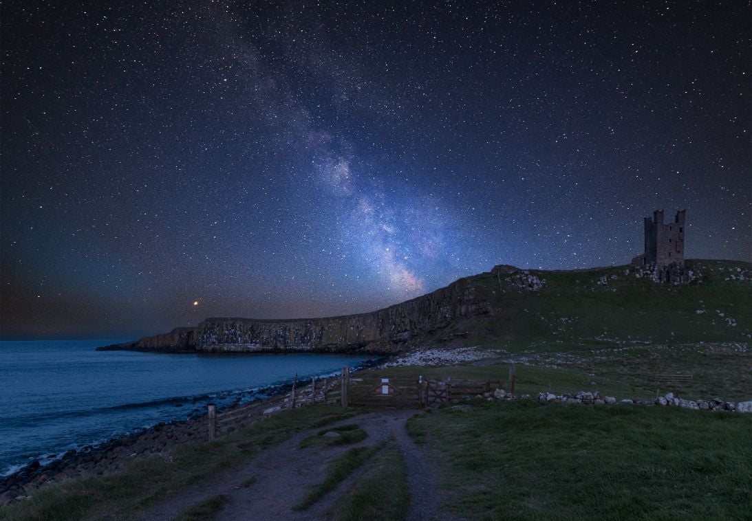 A million stars over Dunstanburgh Castle in the Northumberland Coast AONB. Photo: Getty