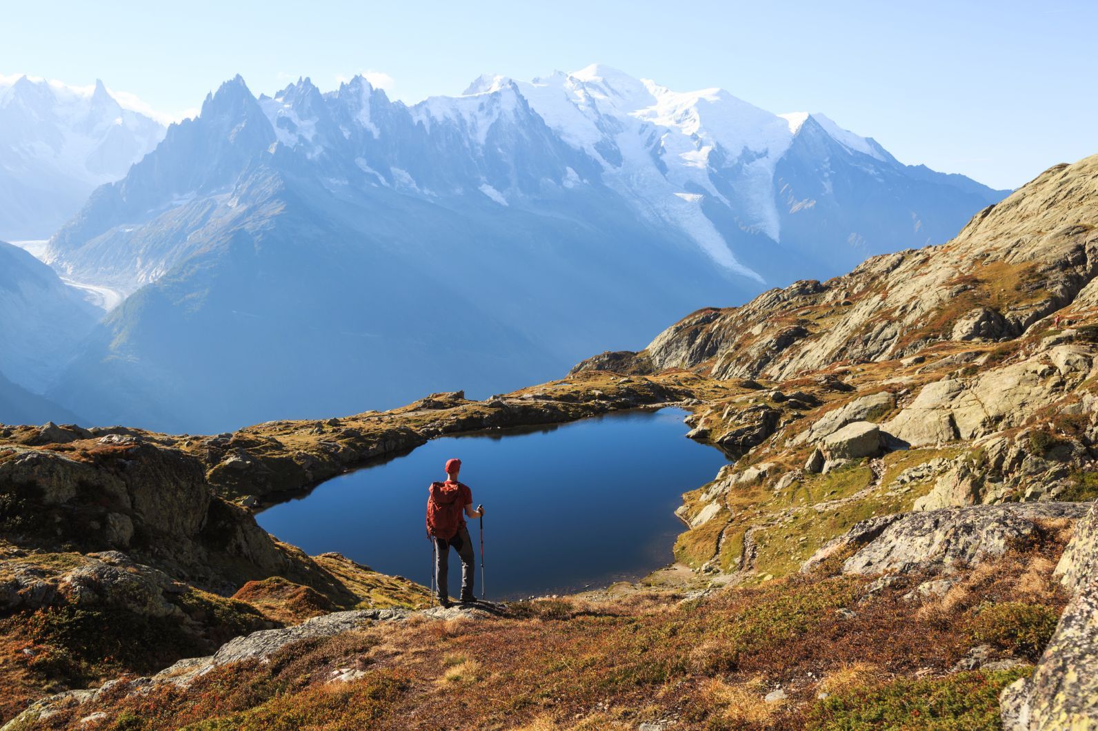 A hiker looking on at the Hiker looking at the Lac des Cheserys on the famous Tour du Mont Blanc near Chamonix, France. 