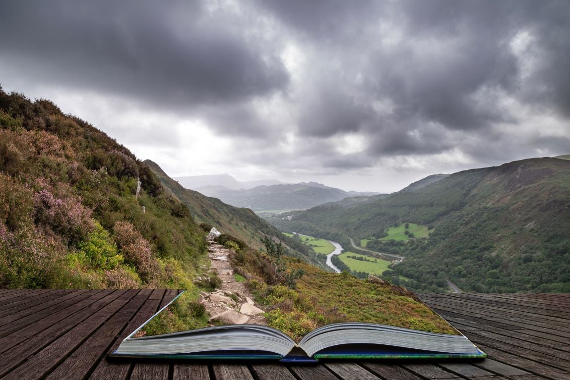 An open guide book blending into the surrounding countryside.