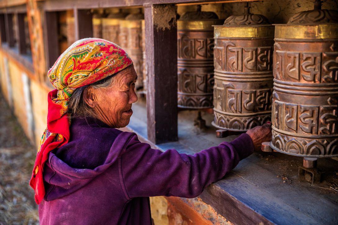 A woman turns prayer wheels in Tibet.