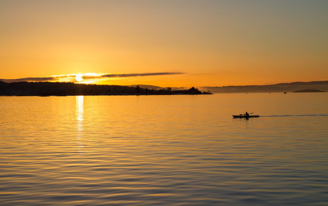 A solitary kayaker at sunset on Oslofjord, Norway