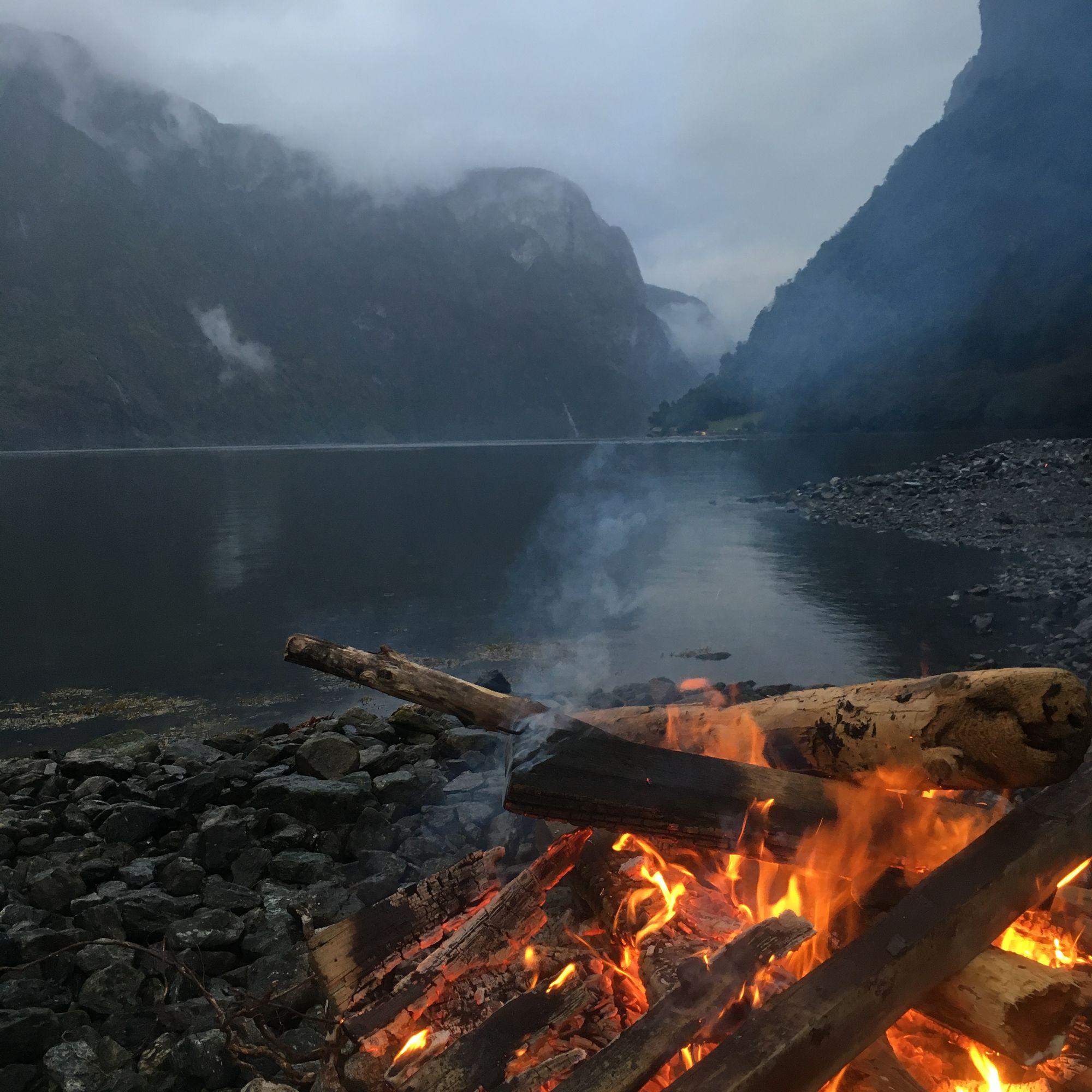A campfire on the edge of a Norwegian fjord.