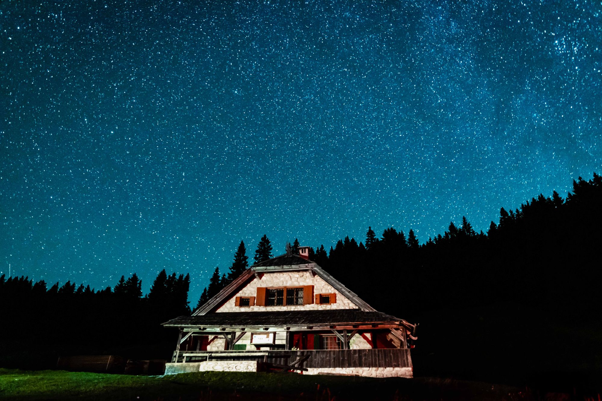 A house in Slovenia backdropped by a starry sky, in Triglav National Park.