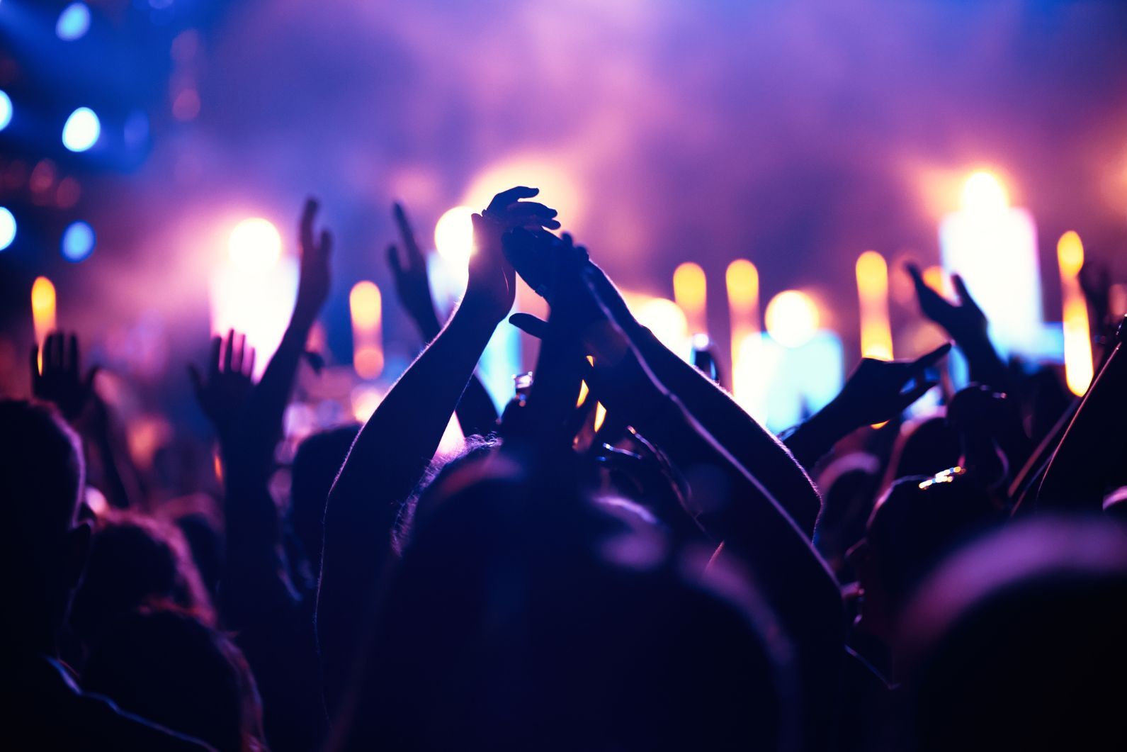 People's hands in the air as they dance at a gig.