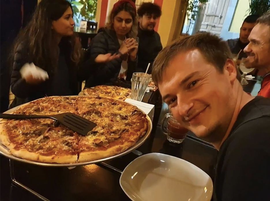 Eating a large pizza with a Much Better Adventures group in Guatemala.