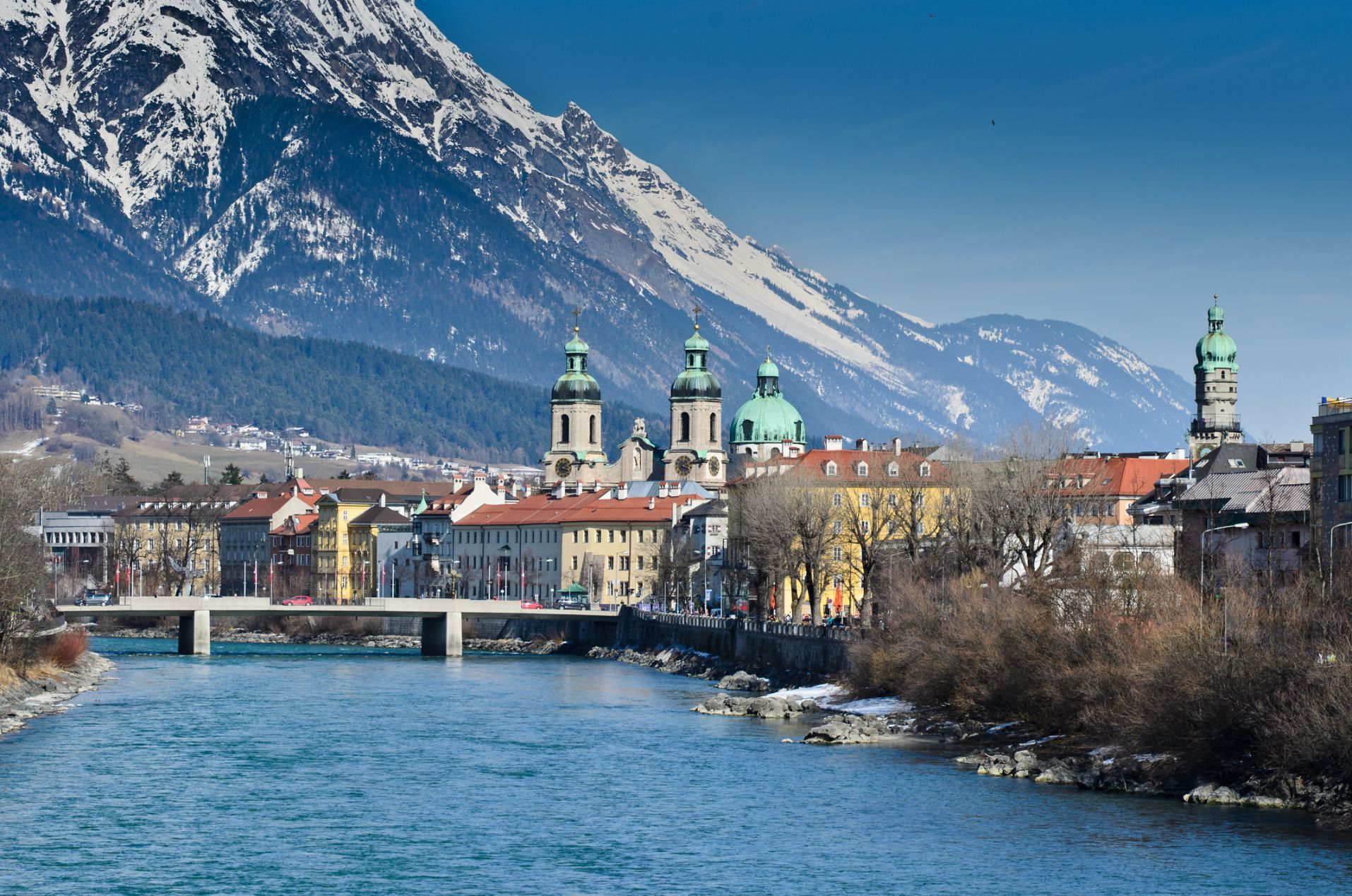 The city of Innsbruck on the River Inn, with snowcapped mountains behind.