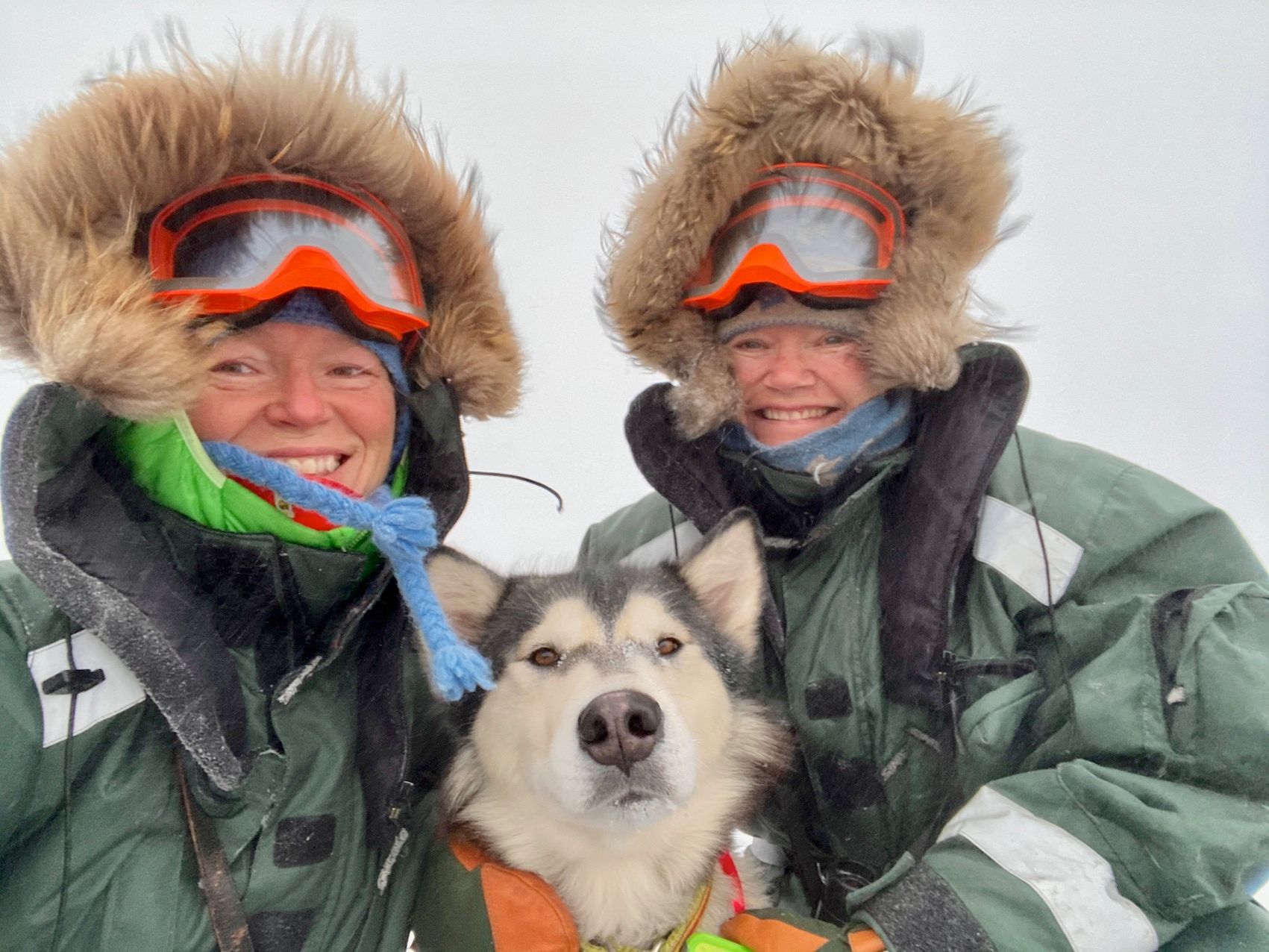 Hilde Fålun Strøm and Sunniva Sorby pose in the Arctic with their dog Ettra.