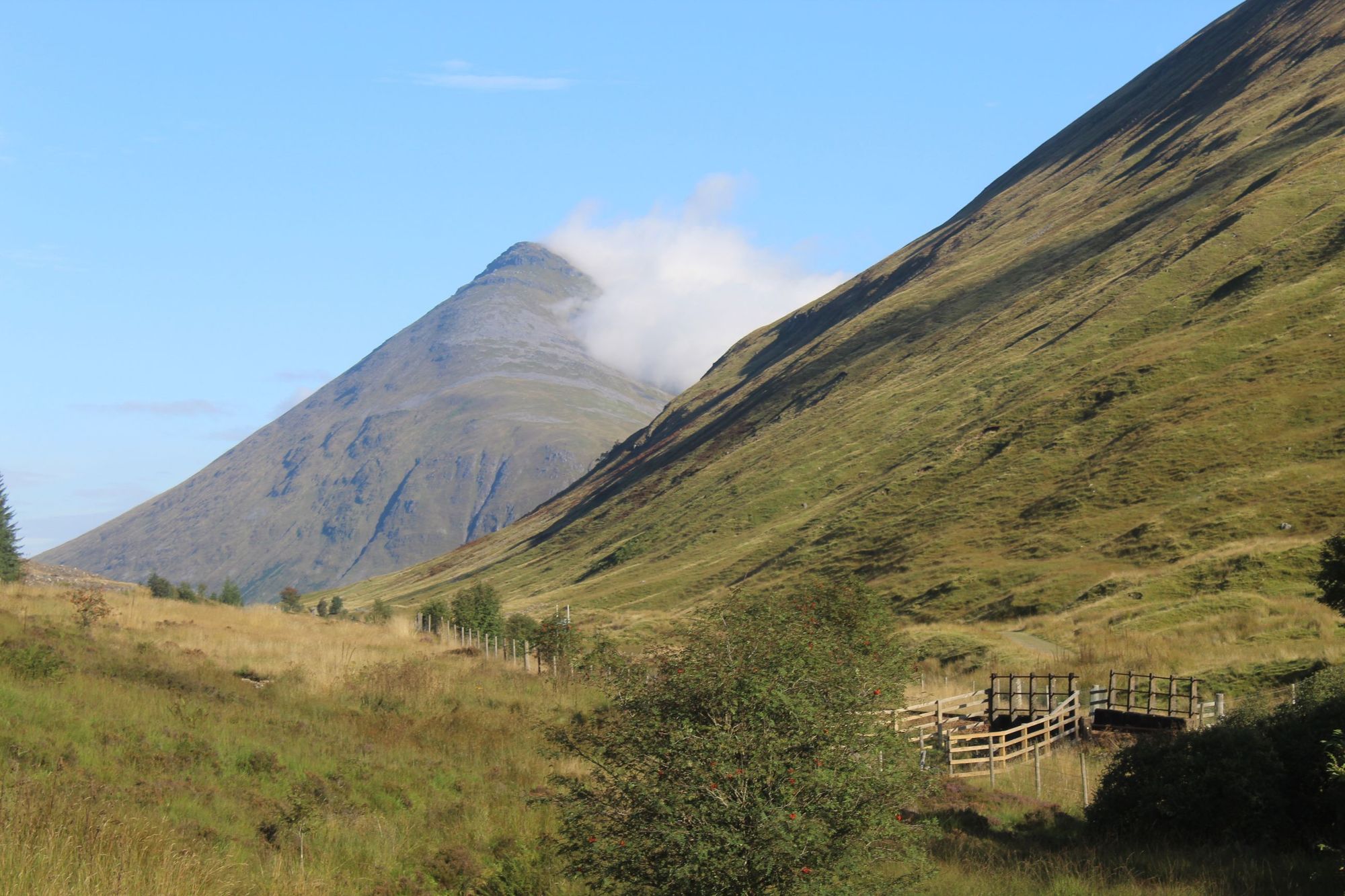 The mountain of Beinn Dorain emerges from the clouds on a sunny day on the West Highland Way