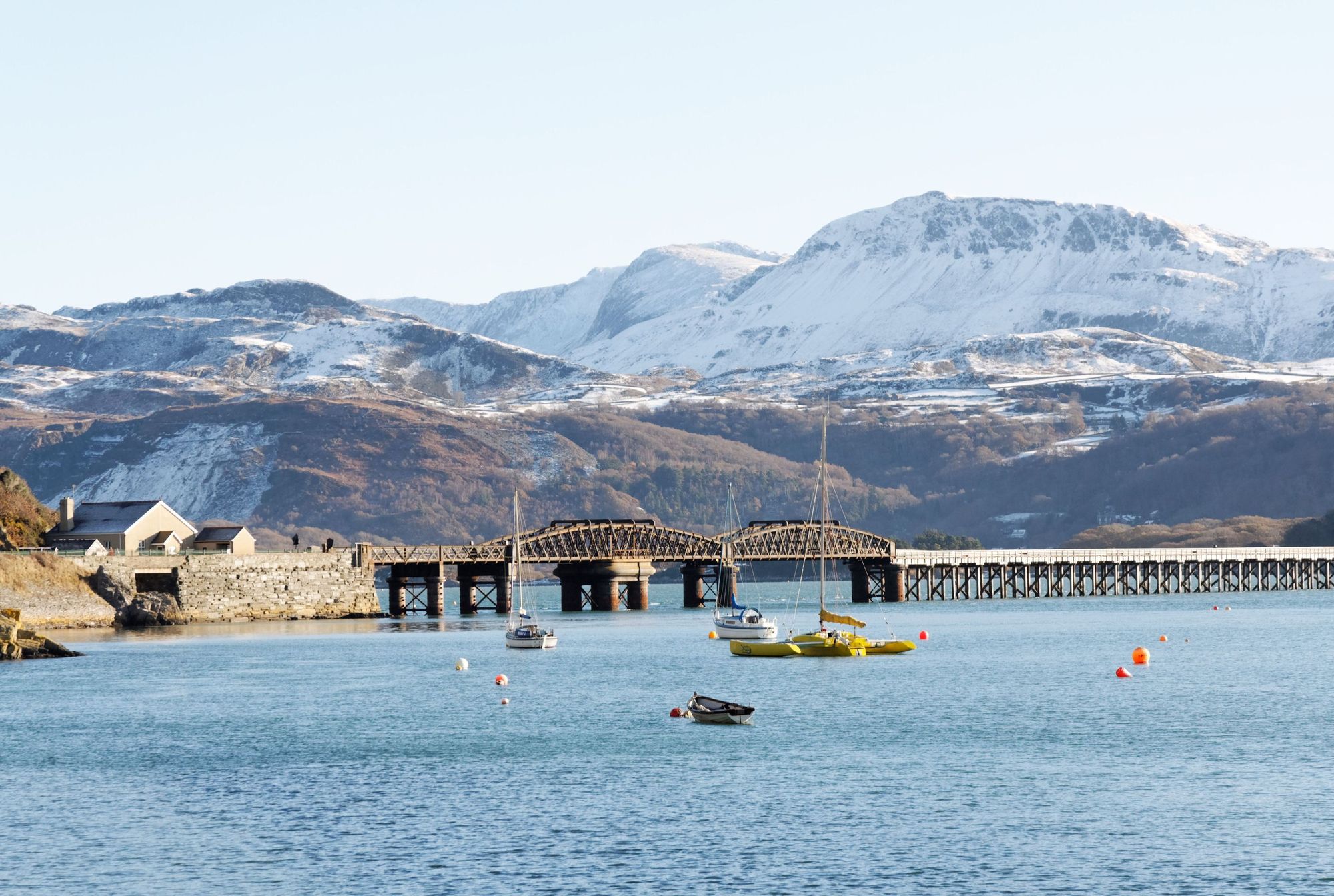 A view of the railway spanning the Mawddach Estuary taken from Barmouth Harbour, with the snow-covered Cader Idris in the background. Photo: Getty