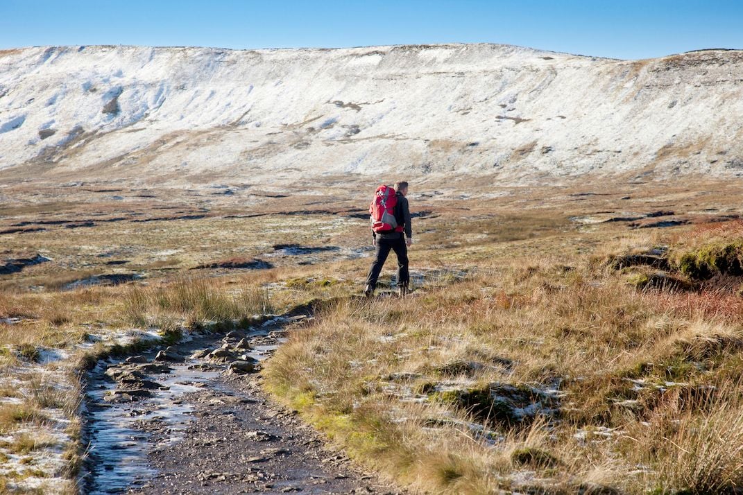 A hiker walking the Three Peaks path up towards Whernside.