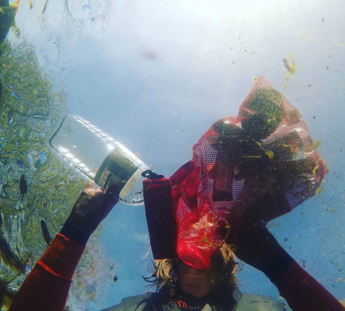 Photo of Laura Owen Sanderson removing rubbish from a river.