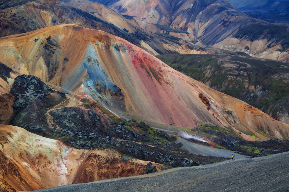 A hiker looking at the rainbow coloured slopes of Brennisteinsalda on the Laugavegur Trail