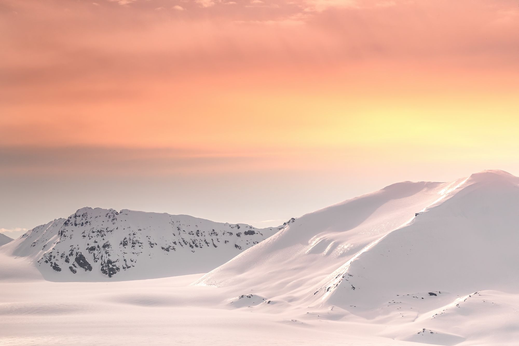 Snow covered hills in the midnight sun on Svalbard. Photo: Getty