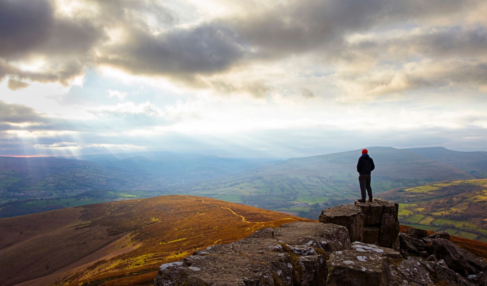 A hiker standing at the top of a hill in the Brecon Beacons National Park.