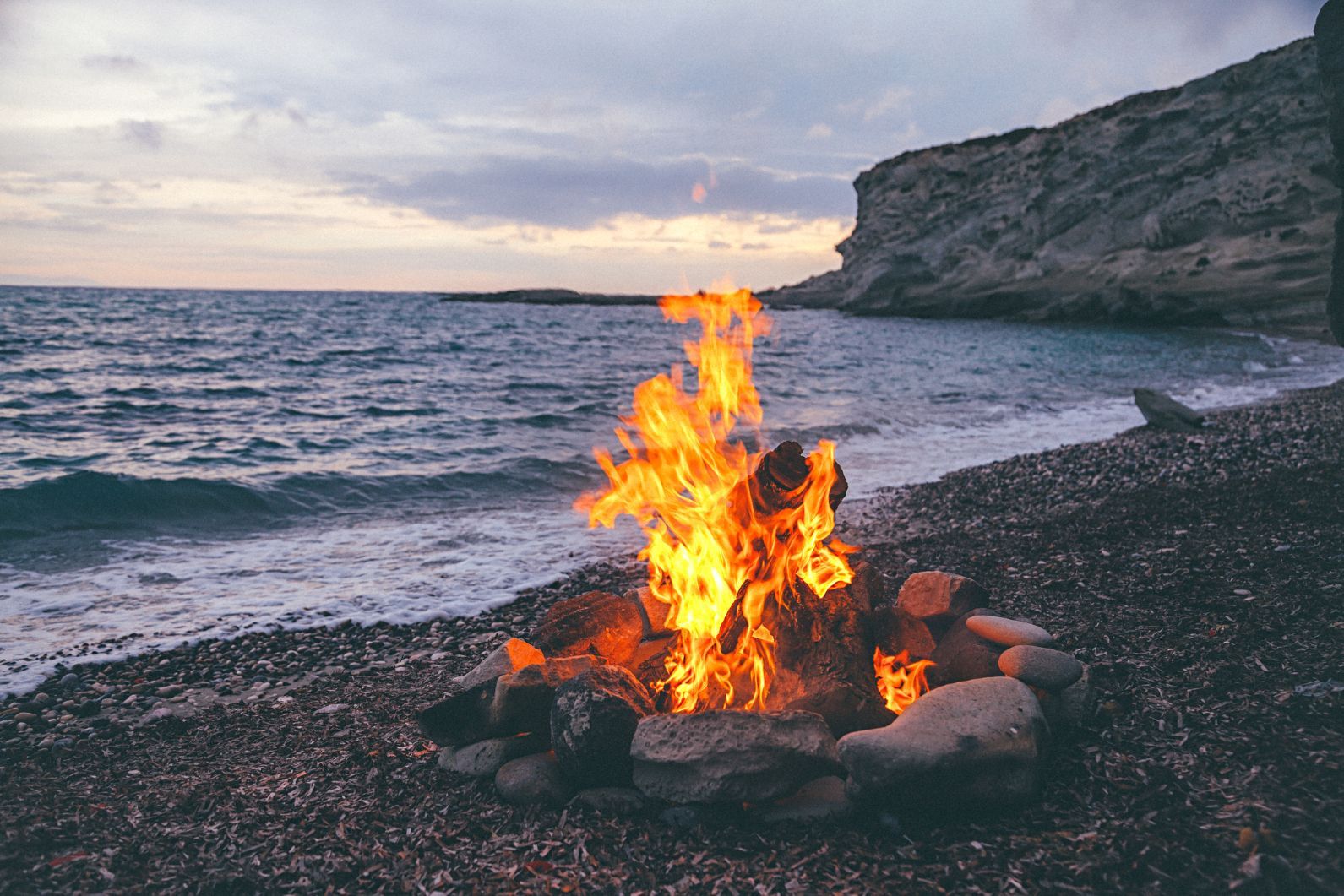 A campfire on a pebble beach