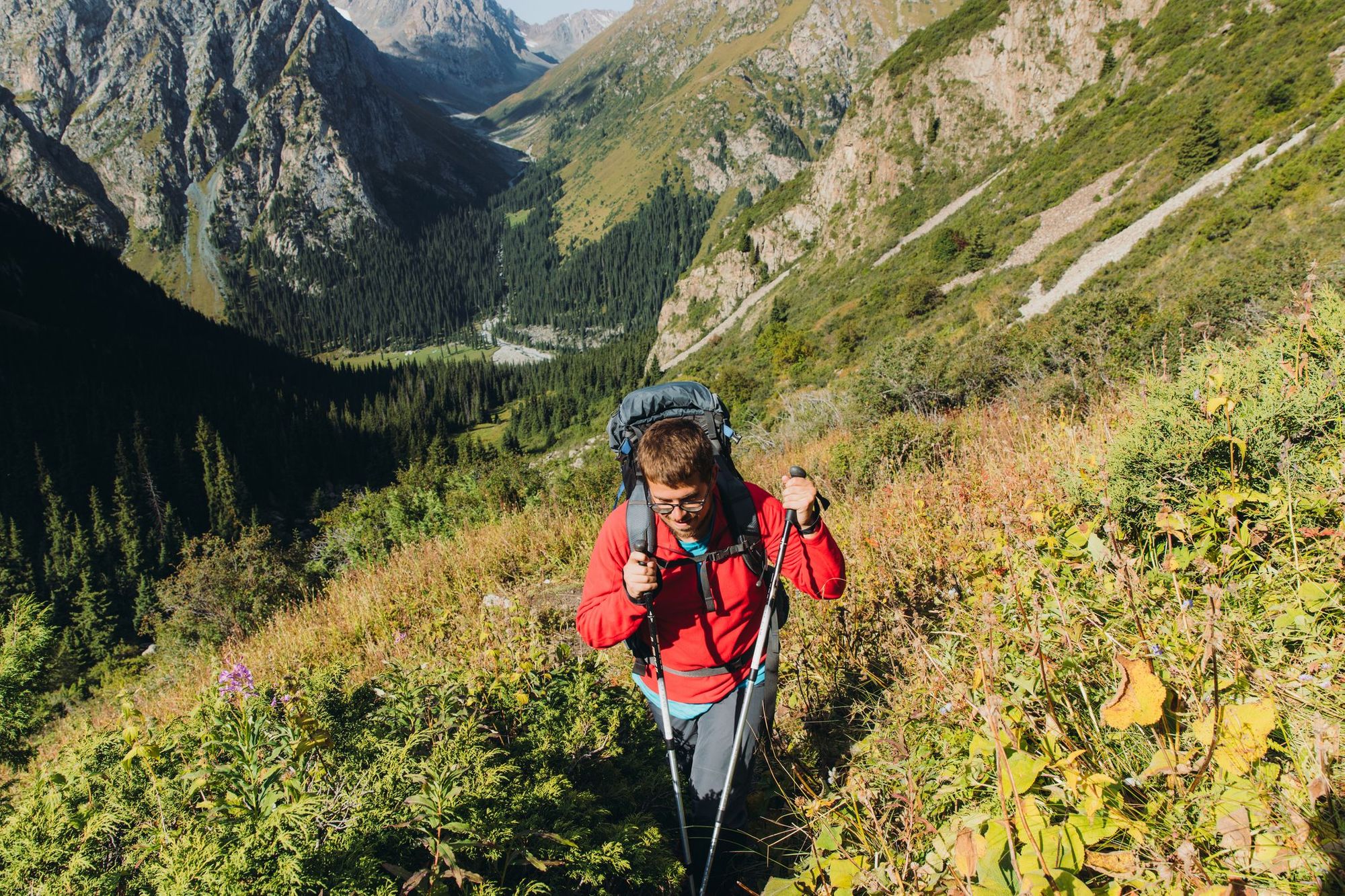 A male hiker on a trail in the mountains of Kyrgyzstan.