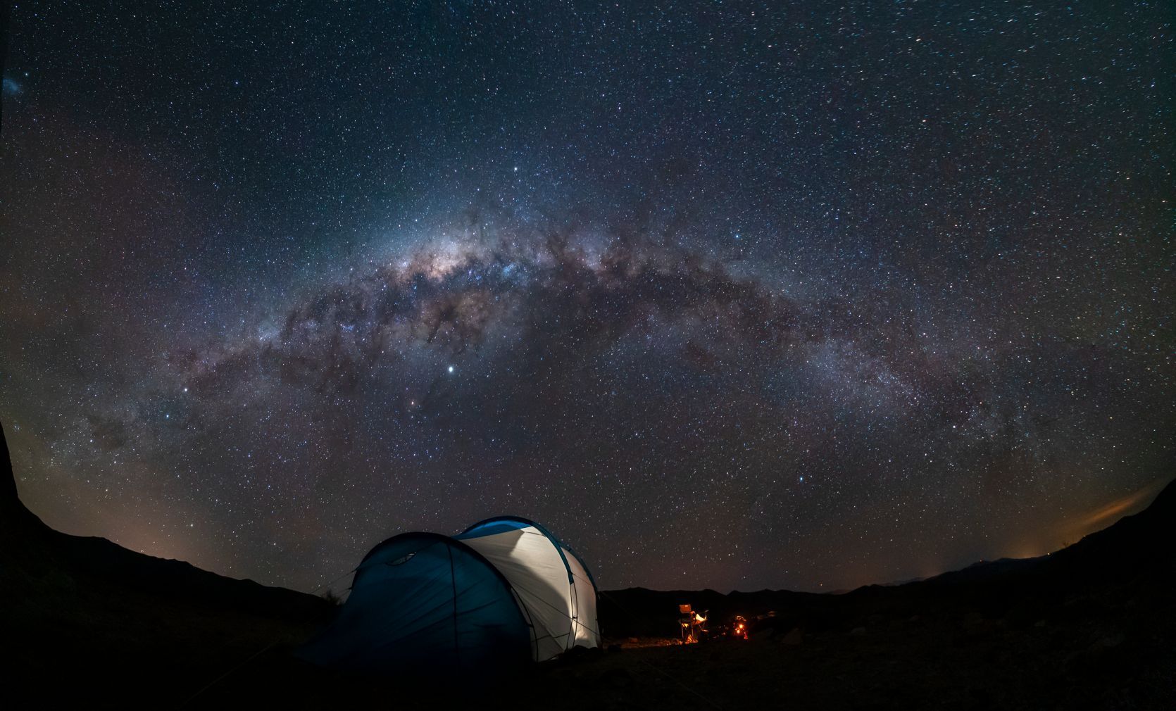 A tent below a starry sky. A photograph of wild camping.