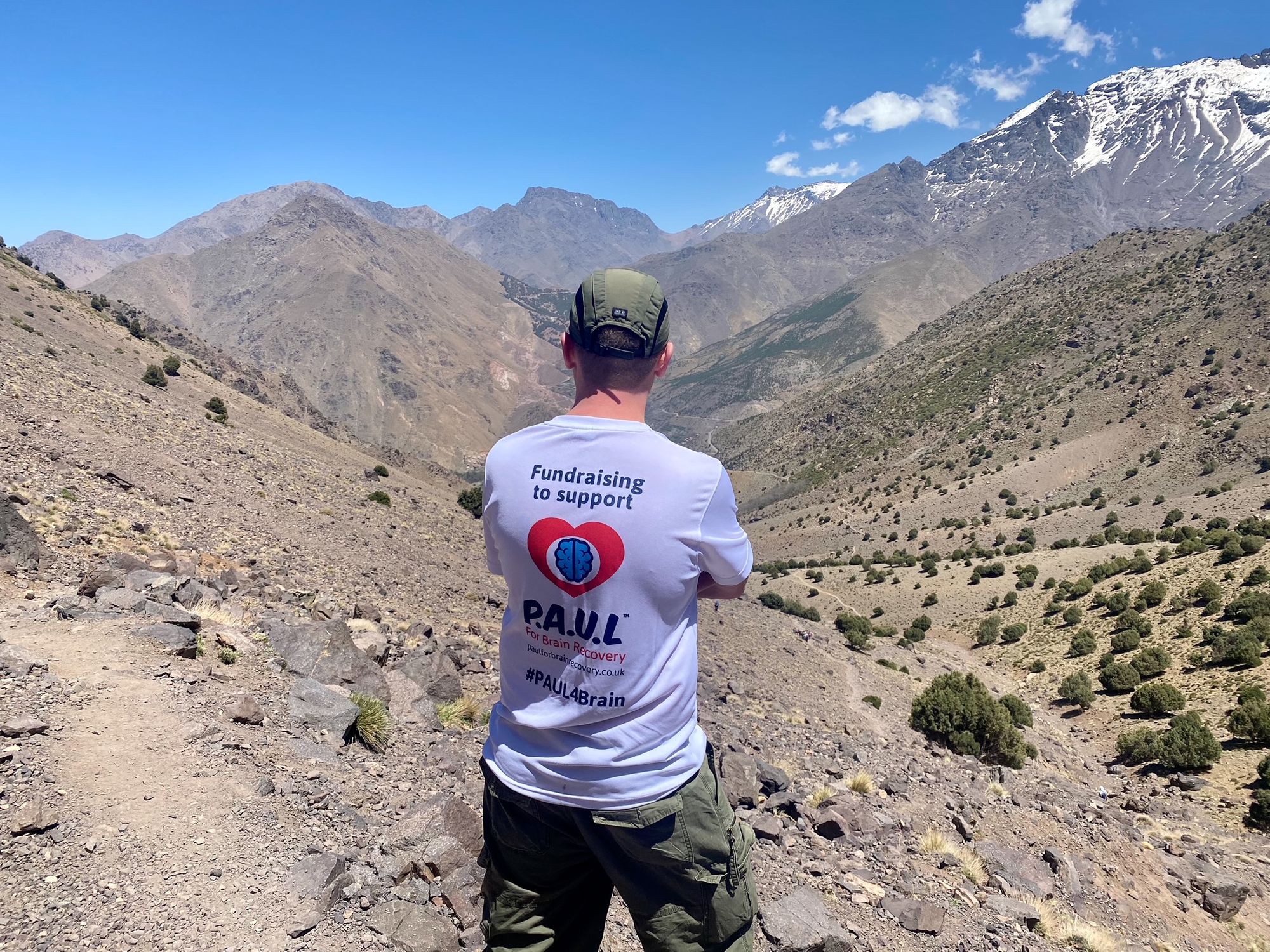 Matt in a P.A.U.L for Brain Recovery t-shirt, looking out over the Atlas Mountains