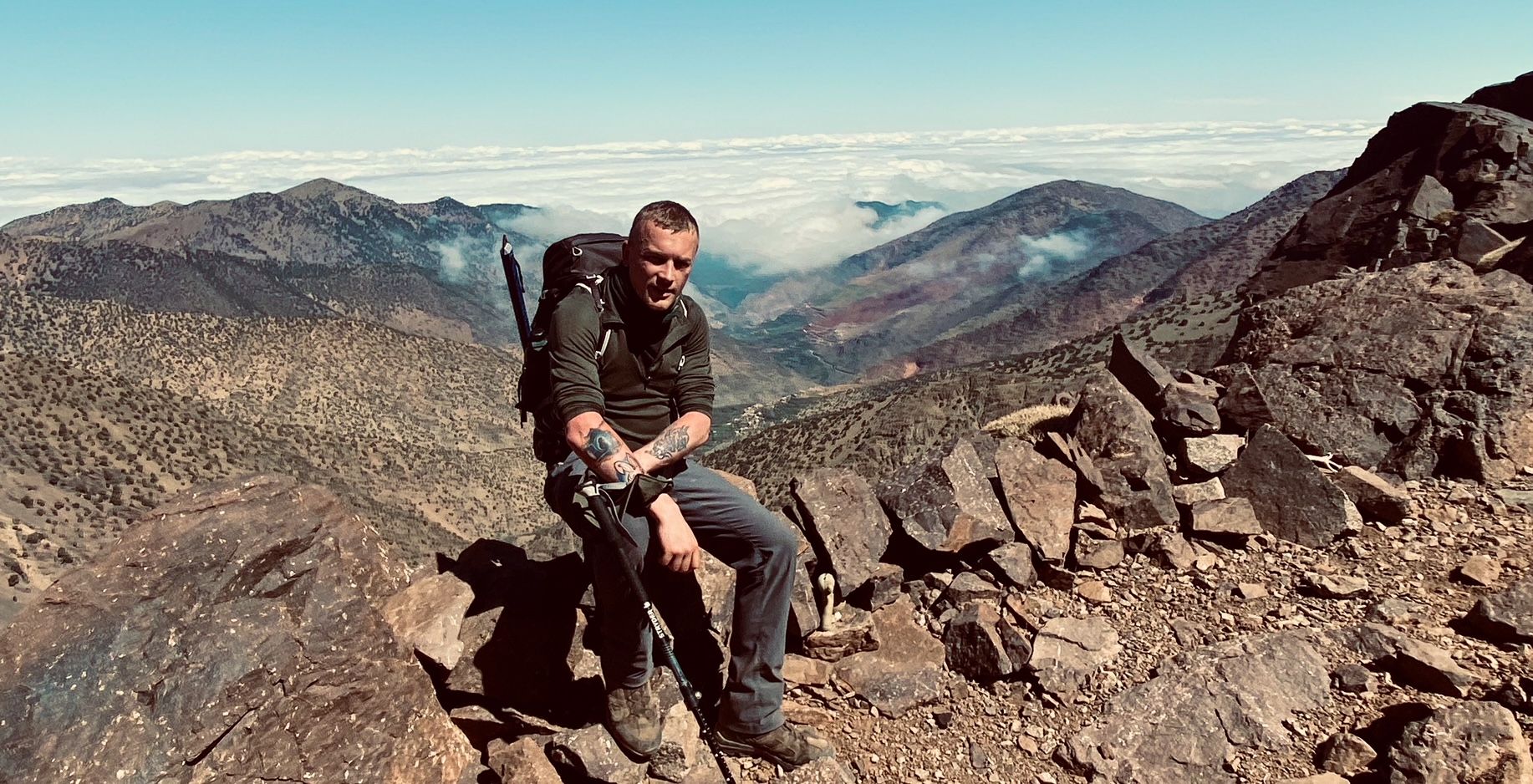 Matt Carpenter sat on rocks with the Atlas Mountains behind him