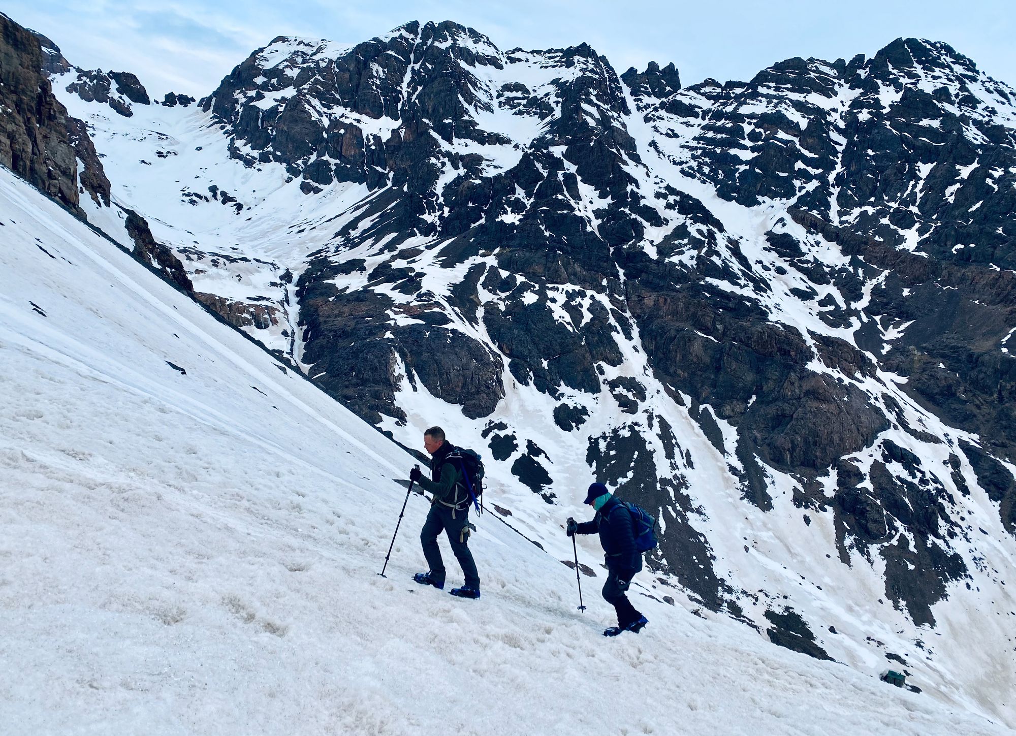 Hikers in crampons tackling the steep, snowy path up Toubkal
