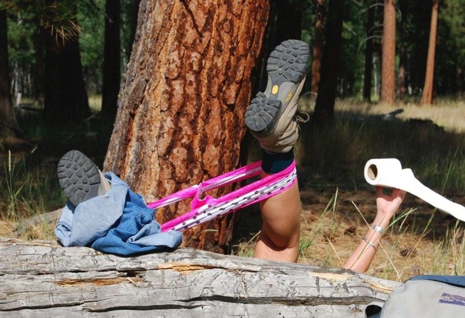 a woman struggles while going to the toilet outdoors