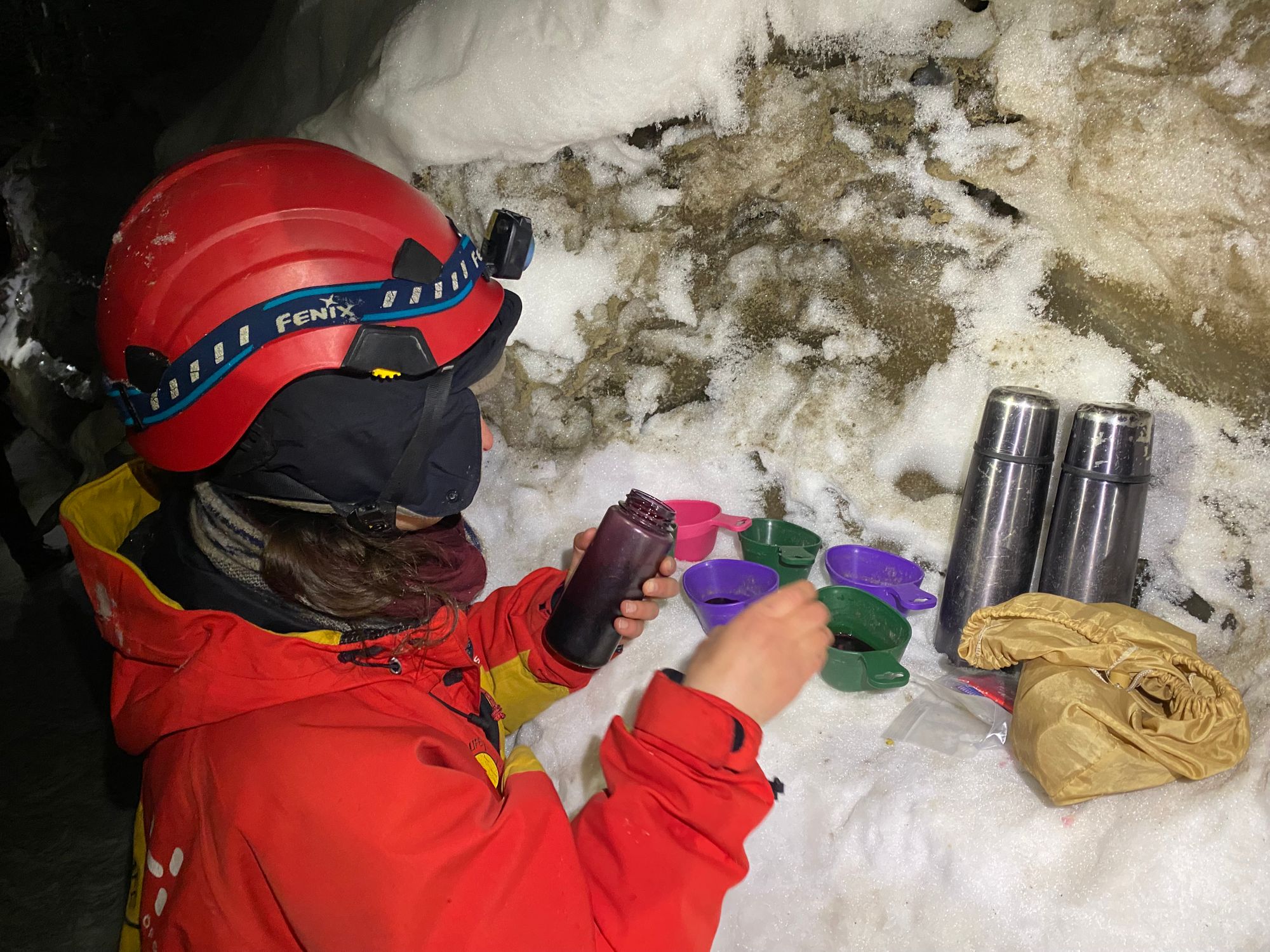 Tea break in an ice cave - flasks on a shelf of snow