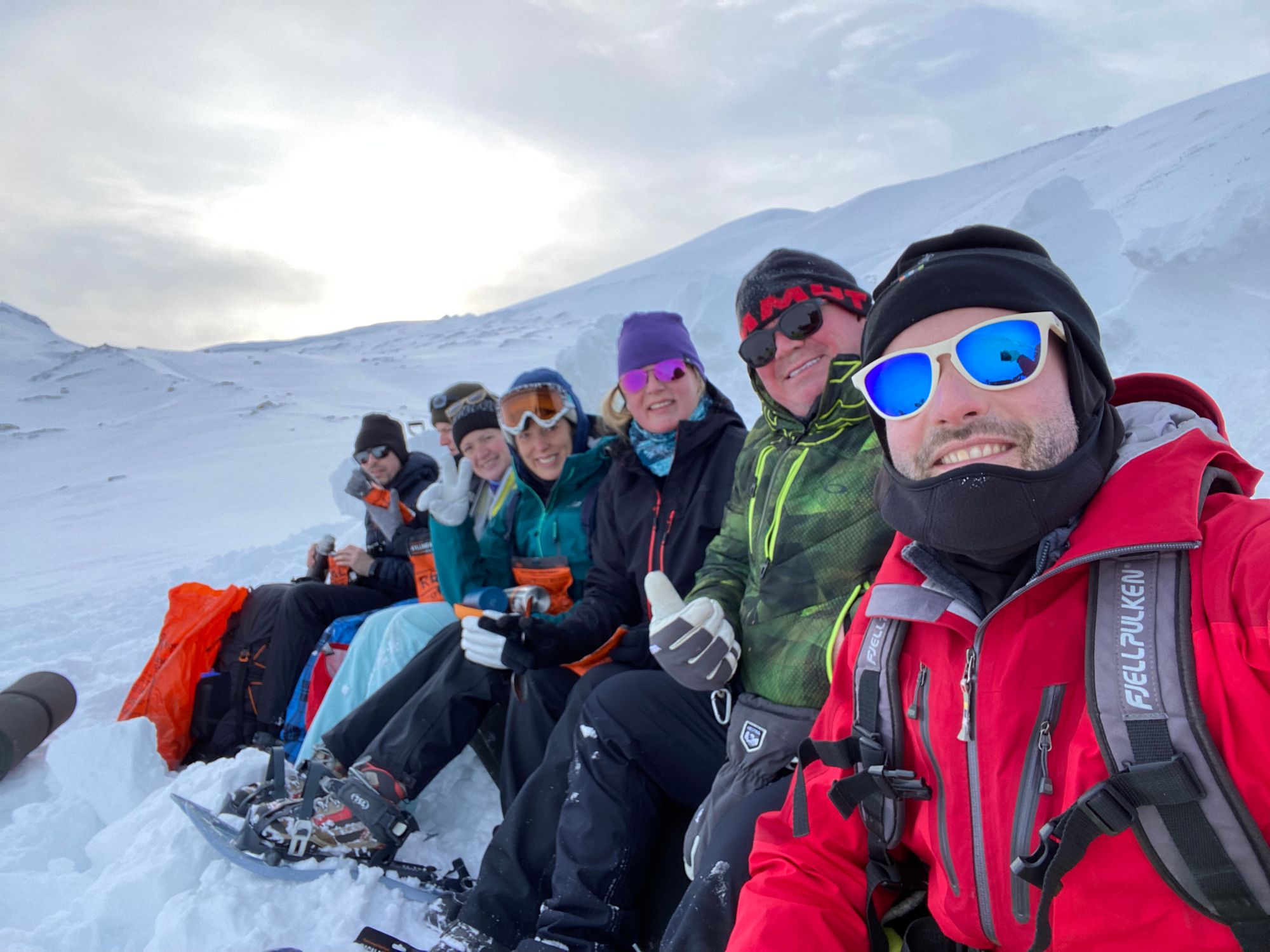 Photo of group enjoying hot drinks in the snow of Svalbard.