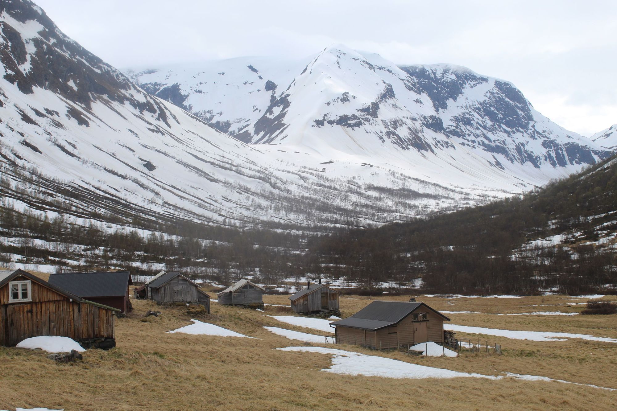 Farm cabins sit in the snow, even in summer, high above the Nærøyfjord, on the way to Breiskrednosi.