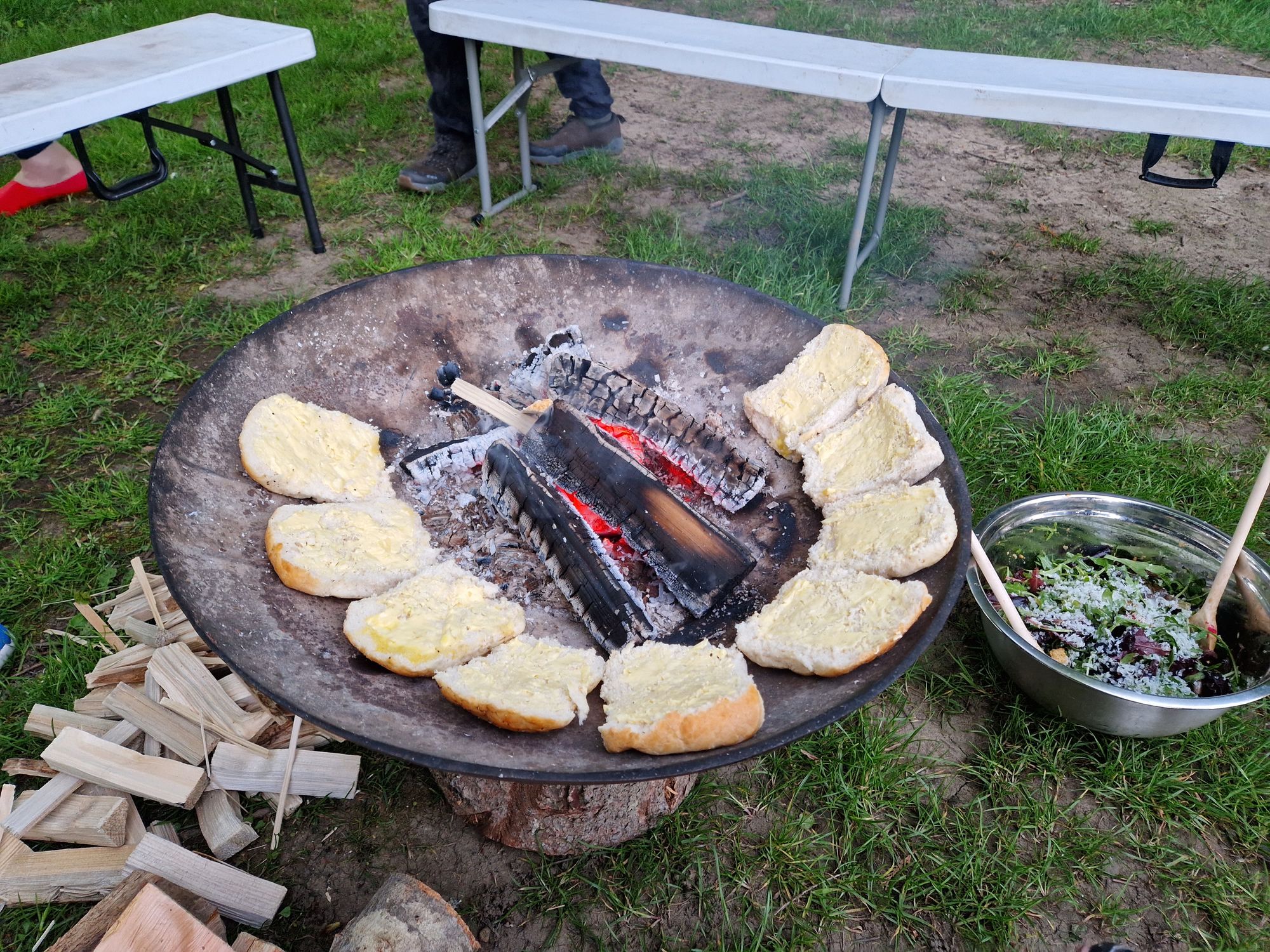 Buttered rolls arranged around the edge of a fire pit.