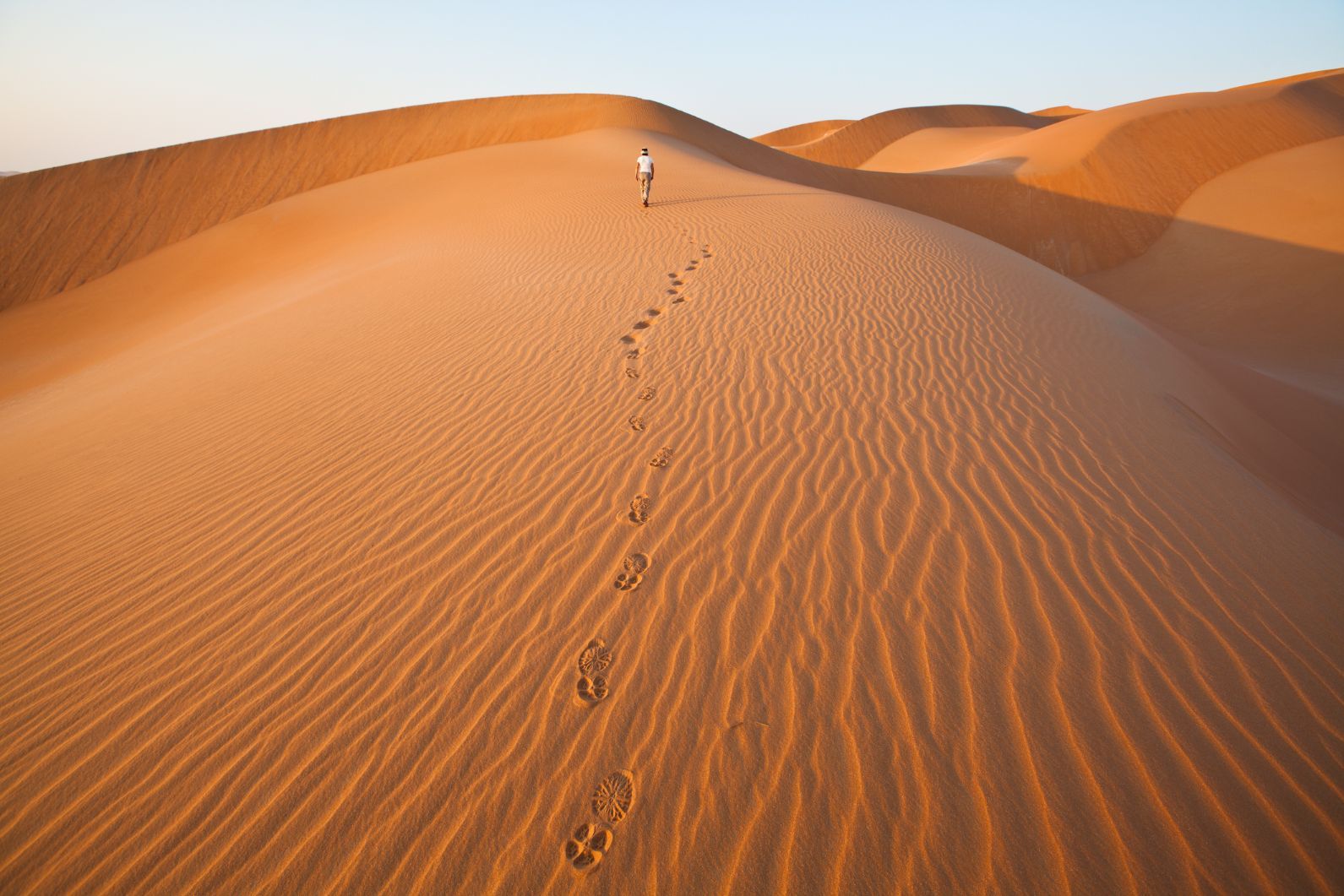 Walking in the sand dunes of Rub al Khali desert Oman