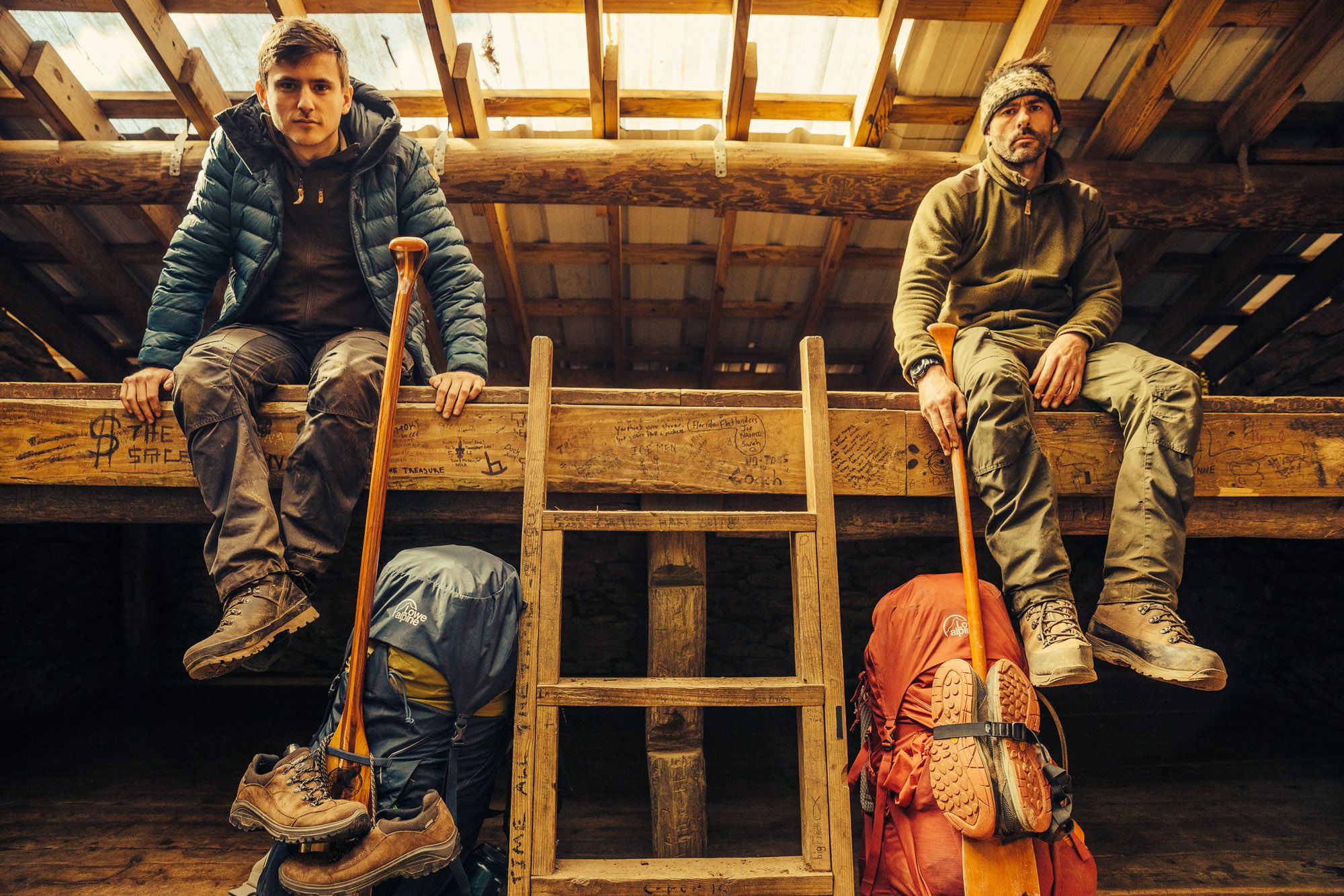 Two hikers in the dormitory of a mountain refuge.