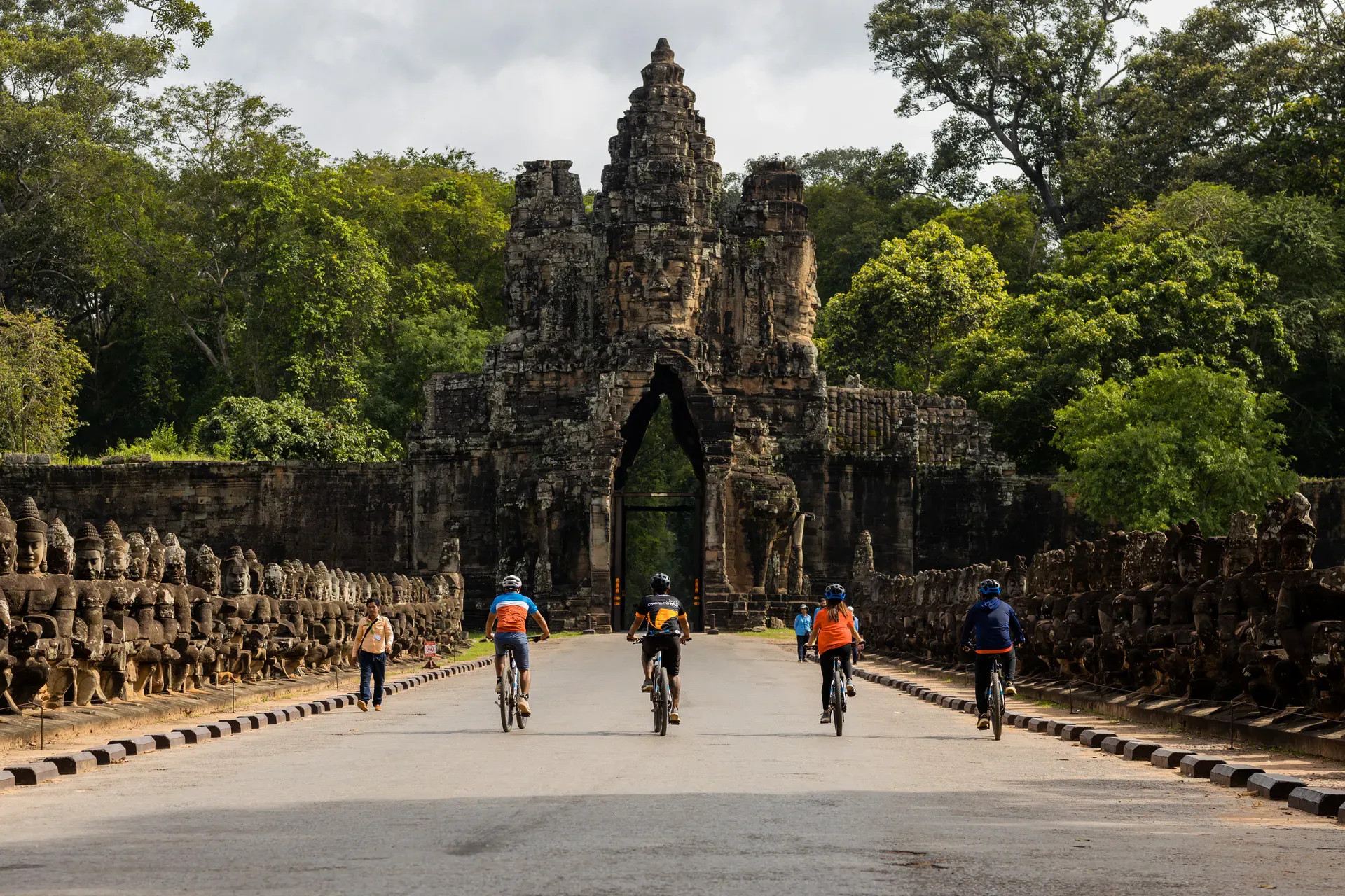 Four cyclists riding towards the entrance of the Bayon, Angkor Wat
