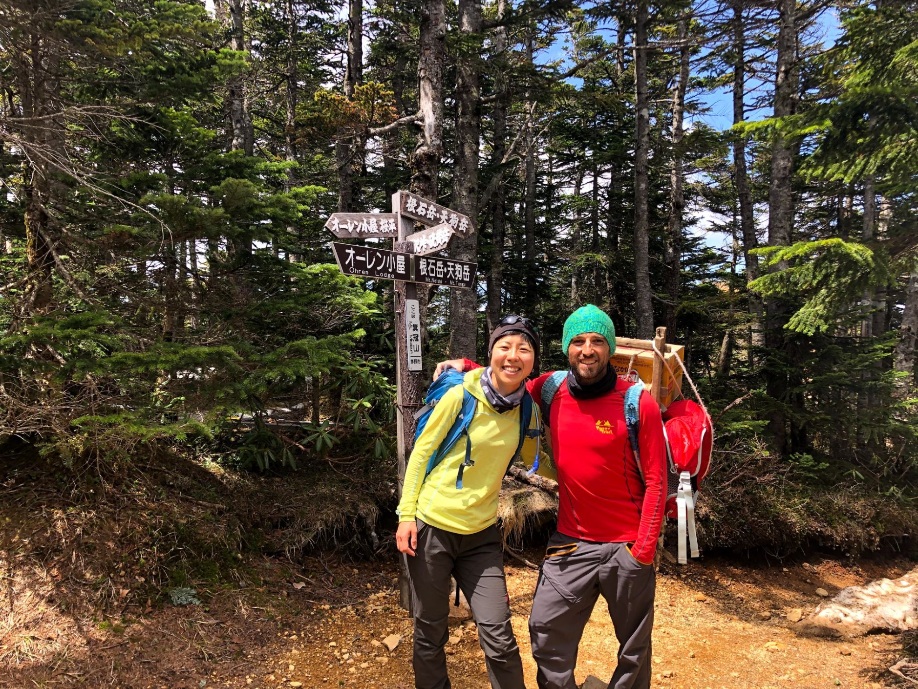 Two hikers pose in a forest.