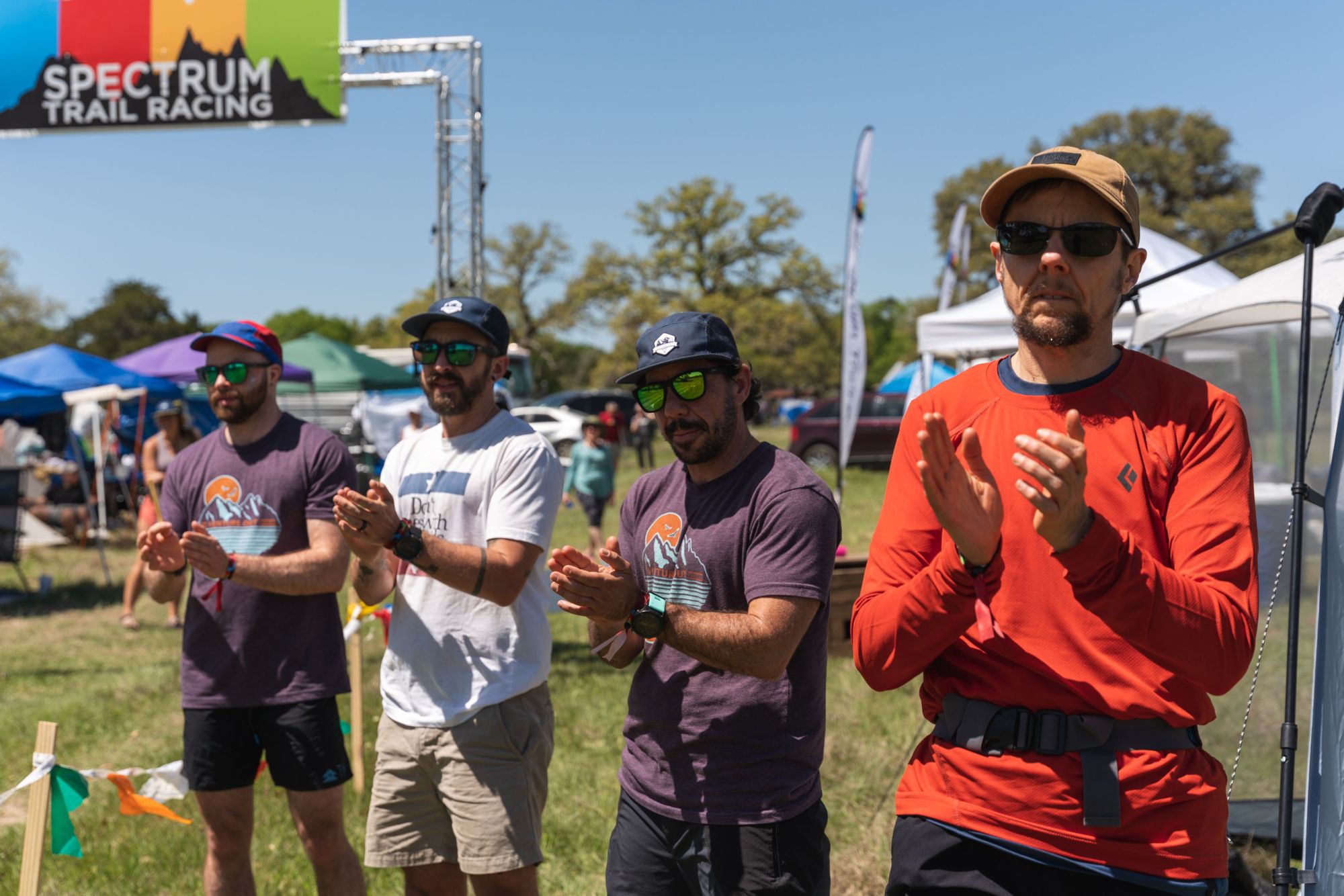 Trail runners applauding at the finish line of a race.