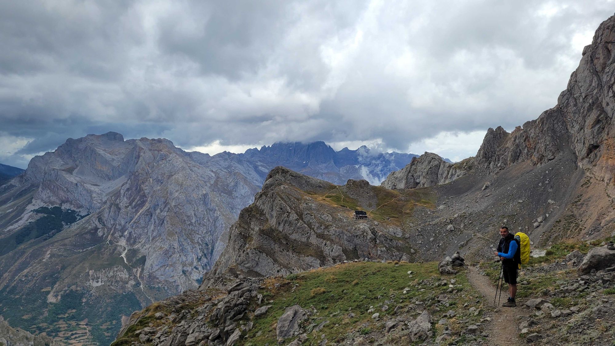 Mountain guide on a path to a mountain refuge in Spain with the Picos de Europa in the background